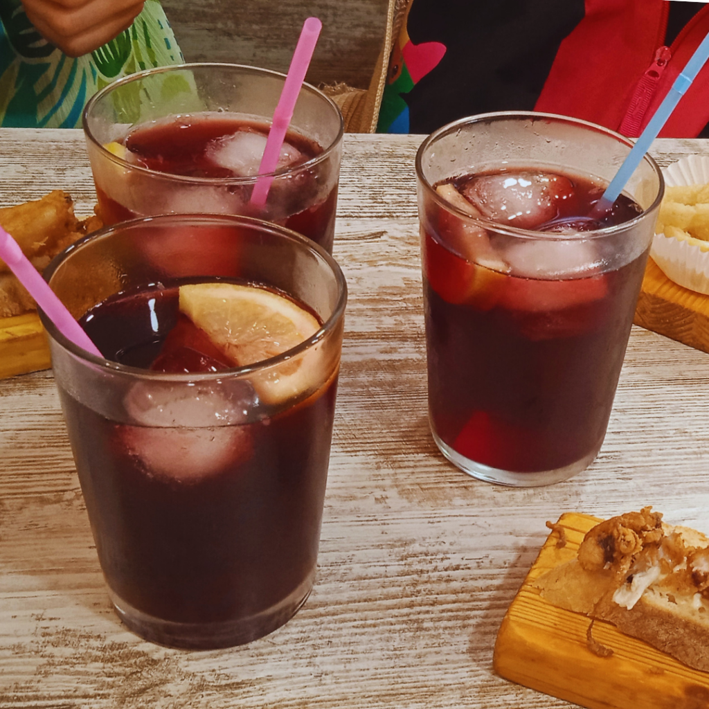 Zdjęcie zawiera 3 szklanki wypełnione sangrią, kostkami lodu i kawałkami cytryny, alkohole bez alkoholu to ciekawy temat